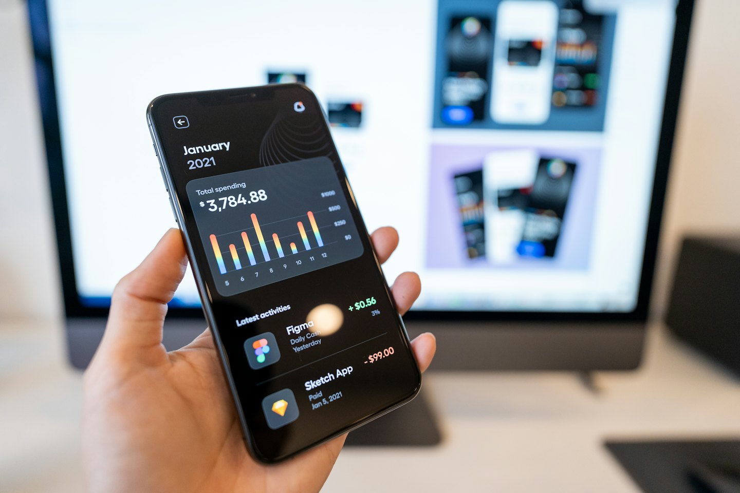 Hand holding smartphone displaying a financial management app.