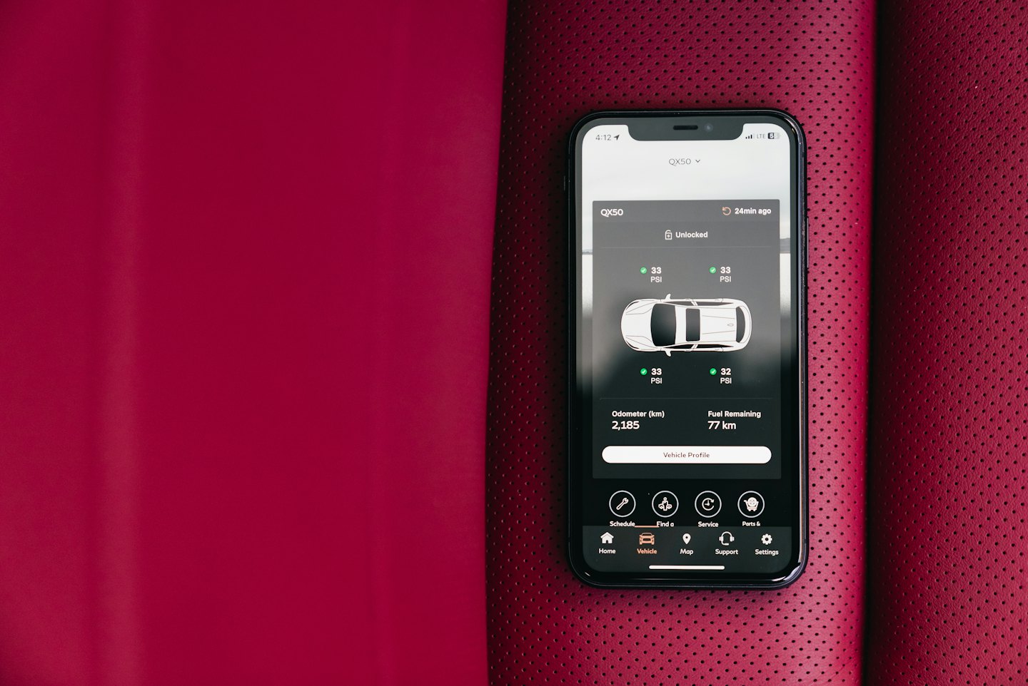 Smartphone displaying a vehicle status app on a car console.